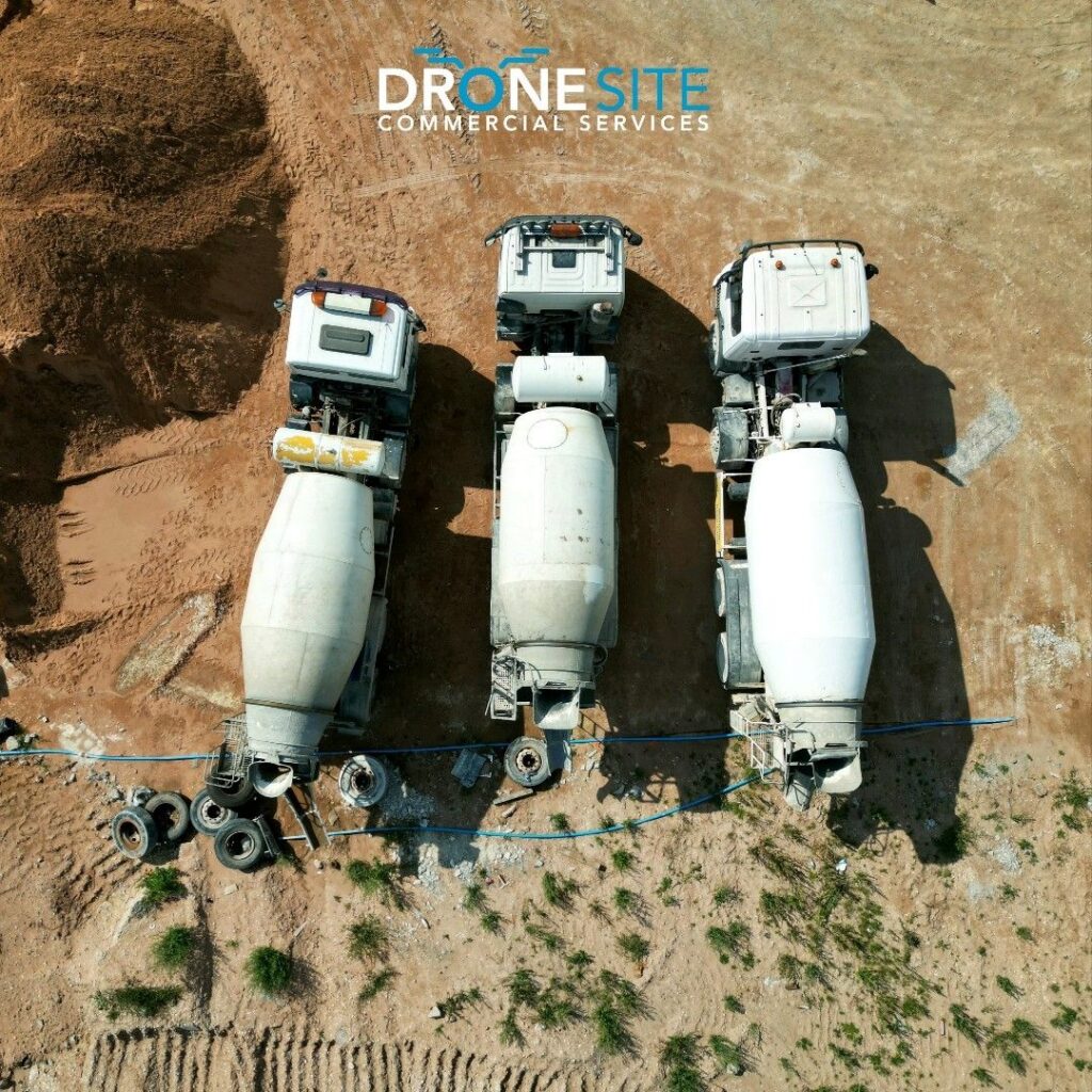 Top-down aerial of concrete mixer trucks on a construction site, by Drone Site